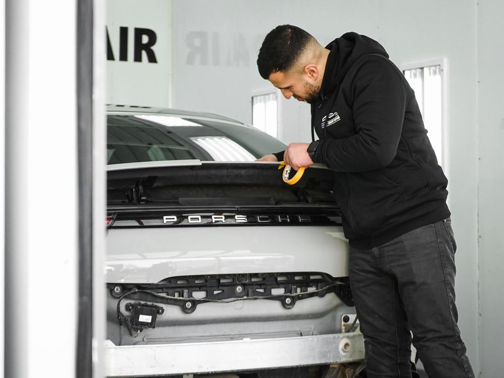 Ates Sekman beim Abkleben eines Porsche in der Lackierkabine